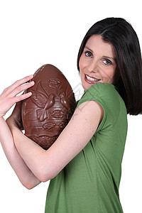拿着大巧克力复活节蛋的女人图片