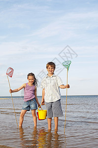 抄网女孩和男孩在海滩玩背景