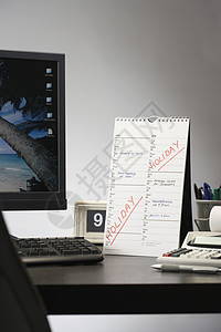 办公室办公桌上有标明假日日历的日历背景图片