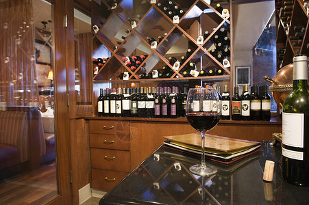 葡萄酒架在葡萄酒店的货架上用瓶装瓶子对葡萄酒玻璃进行近视背景