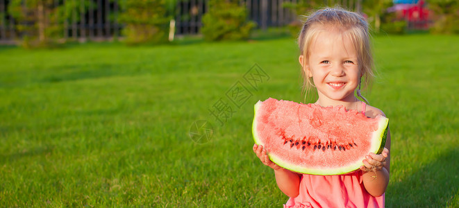小女孩 拿着大西瓜 大块西瓜手握着绿草 假期背景图片