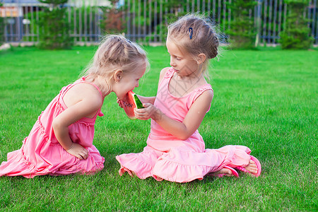 小女孩挑瓜可爱的小女孩 在夏天吃一个成熟多汁的西瓜背景