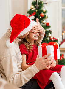 圣诞节家庭微笑的父亲用礼物盒给女儿惊喜 眼睛 孩子 圣诞老人背景