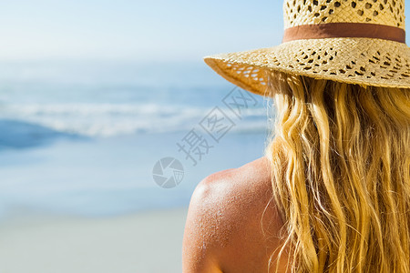 在海滩上晒日光浴的漂亮金发美女背景图片