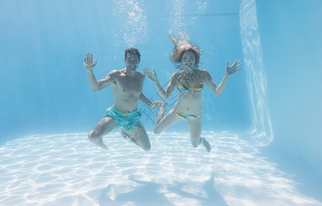 可爱的一对情侣在游泳池水下 冲着相机微笑 夫妻 户外背景