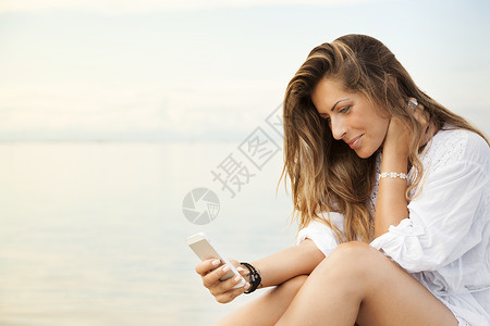 手机水使用手机微笑美丽的年轻女性的美丽女士背景