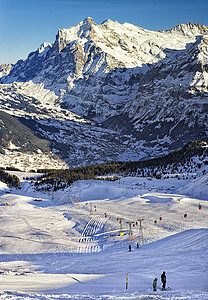 少女峰缆车人们在冬季运动的有线铁路附近滑雪和滑雪板上背景