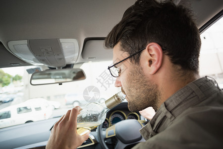坐着喝酒的男人男人在开车时喝酒 男性 坐着 车辆 威胁生命 方向盘 运输背景