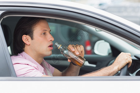 坐着喝酒的男人男人在开车时喝酒; 微醉 车辆 威胁生命 坐着 男性背景