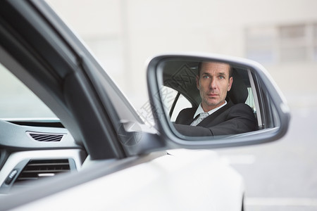 肌肉男座驾在后视镜中反射的行人驾着汽车驾驶背景