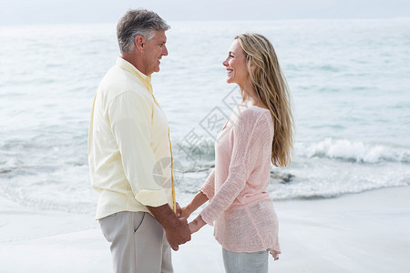 幸福的情侣手牵手 互相微笑 空余时间 周末活动 海 海滩背景图片