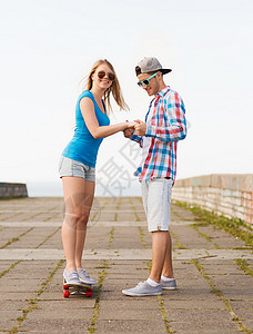 在户外带滑板微笑的情侣 乐趣 出去 浪漫的 滑板手 帽子背景图片