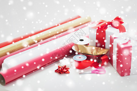 红色丝带卷轴圣诞礼物的紧闭 雪花 剪刀 传统的 弓 丝带 红色的背景