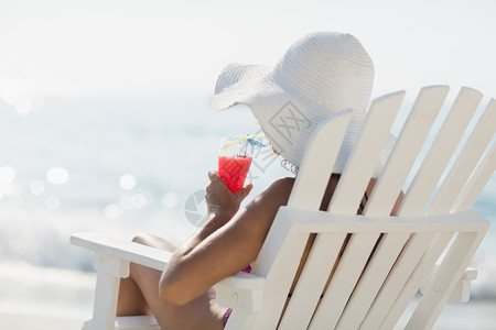 穿泳衣的棕发美女 太阳帽 坐着 支撑 美丽的 假期图片