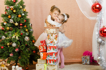 五年高考三年模拟两个小女孩在圣诞节时 拥抱着对方的圣诞礼物背景