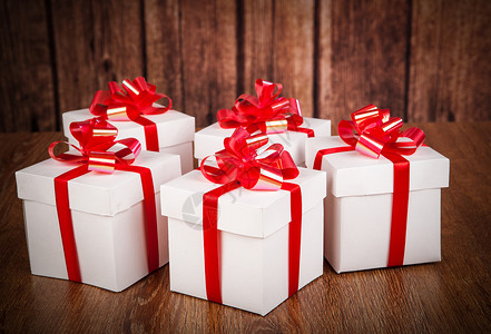 木材背景上许多白色礼物盒 展示 红色的 欢乐 圣诞节背景图片