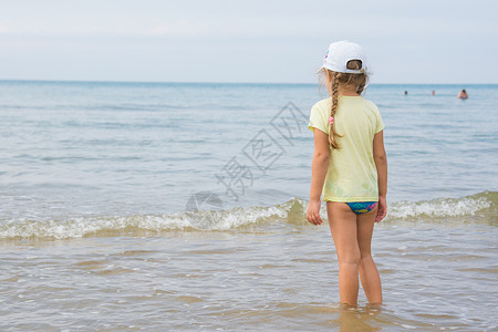 一个女孩站在岸边 望着海的远处图片