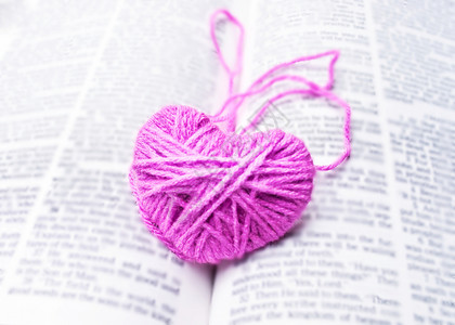 读本书修在心写在书上的粉红心编织羊毛 为情人节的情人节 纤维 工艺背景