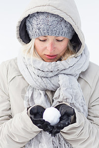 女孩在寒冷的冬天拿着雪球 冰冷的 滚雪球 霜 抓住背景图片