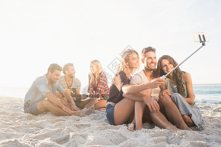 坐在沙沙上欢唱和自拍的笑笑朋友 波浪 漂亮的 坐着图片
