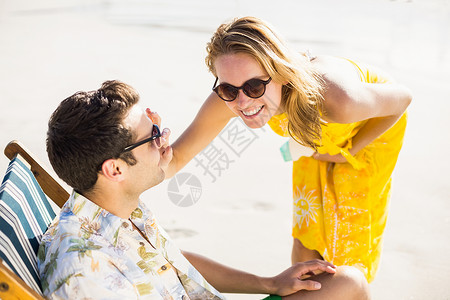 快乐的女人在男人鼻子上施润湿剂 微笑 金发女郎 男性图片