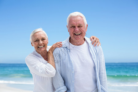 岁月已老在沙滩上拥抱老夫妇的情侣 高级的 波浪 海滩 代背景