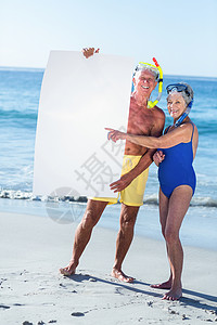 持有白海报 带海滩设备的老年夫妇 有沙滩设备 背景图片