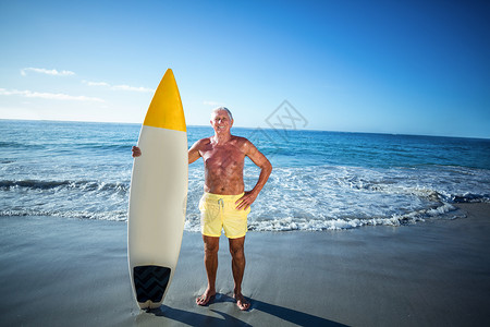 高级男子摆着冲浪板 双手 海 老年 快乐 海滩 快乐的背景图片