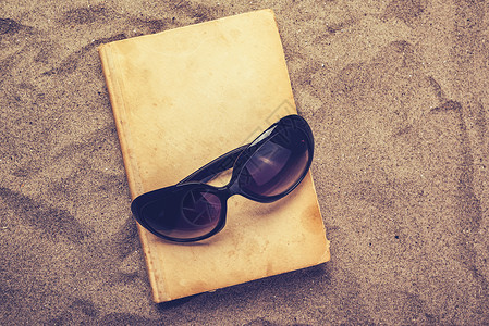 阅读关于暑假海滩假日最喜爱的旧书 低俗小说 太阳镜高清图片