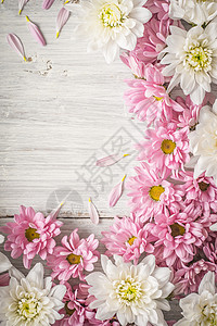 白色木制桌垂直的白花和粉红花边框背景图片