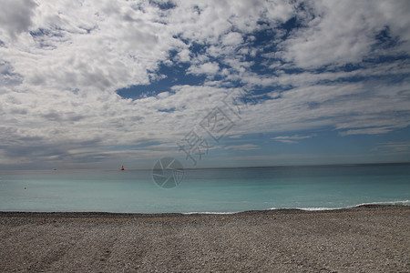 蓝色地平面和远距离帆船的碎石海滩 全景 夏天背景图片