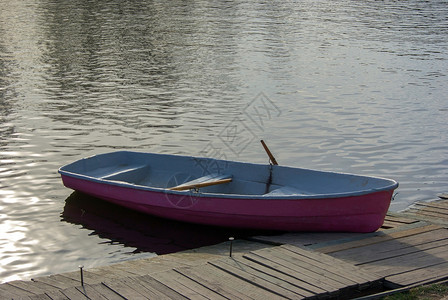 粉红划船 停在湖边码头图片