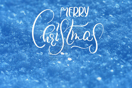 雪纹理在蓝色口气背景与文本圣诞快乐 书法与字体背景图片