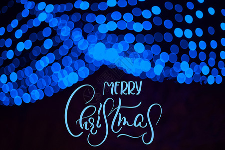 在冬季公园装饰品中的蓝色模糊的加兰 有文字 圣诞快乐 书法和字母背景图片