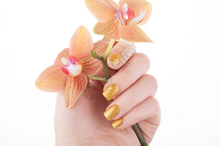 美丽的金色美甲 手指 关心 化妆品 活动 凝胶 花朵 假期背景图片
