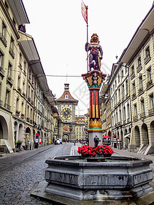 瑞士伯尔尼精致喷泉顶部色彩缤纷的中世纪 Zahringen 雕像的美丽城市街景 喷泉归功于 16 世纪的 Hans Gieng背景