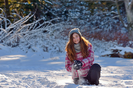 少女在雪中玩耍 圣诞节 冬天 滚雪球 女孩 青年 微笑 衣服背景图片