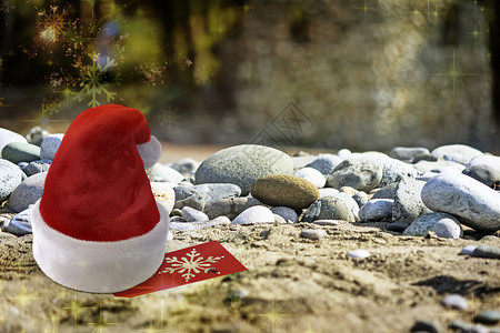 圣诞海滩上的圣诞老人帽子 在海滩上 海浪 圣诞节背景图片