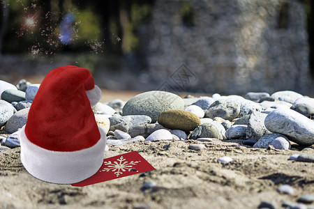 圣诞海滩上的圣诞老人帽子 在海滩上 圣诞节 绿色的背景图片