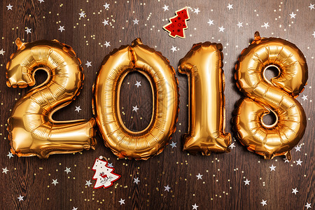 2018年 圣诞节 新年气球 黑色木质桌底有闪亮星的亮金金色气球 五彩纸屑 开朗背景图片