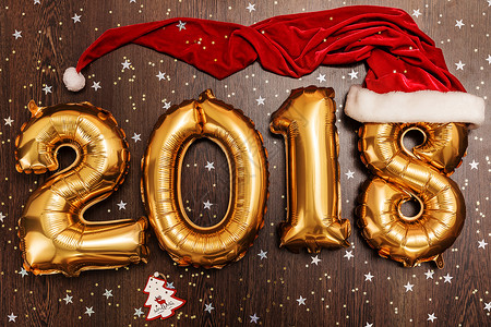 2018年 圣诞节 新年气球 黑色木质桌底有闪亮星的亮金金色气球 快乐的 光滑背景图片