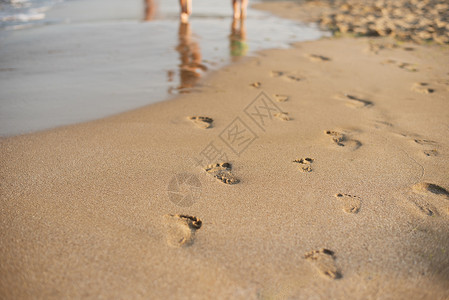 在沙滩上的脚印 远离观众的人类脚印 夏日沙滩上的一排脚印 暑假图片