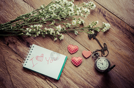 请注意 一封写有“我爱你”的信和放在纸旁边的心形花钟 - 情人节的概念背景图片