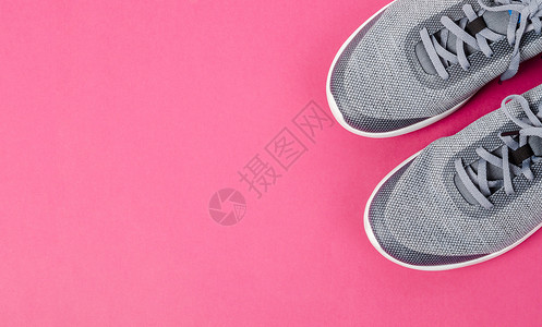 粉红色背景的灰色运动鞋 女性 购物 健康 配件 空的背景图片