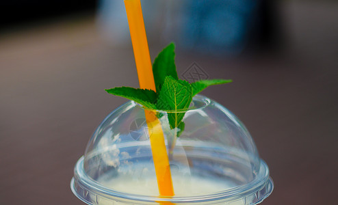 果汁画册封面Pina Colada鸡尾酒在有封面和管子的花瓶玻璃中 薄荷叶放在封面上 近视背景