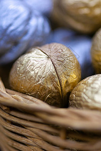 柳条篮子里的银色和金色假日糖果坚果 礼物 庆典背景图片