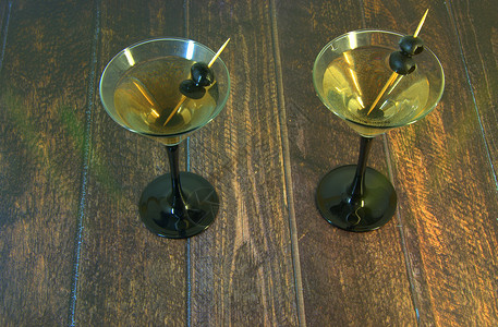 牙签杯两杯全马提尼杯 两颗橄榄放在木制桌子上的牙签摊子上 喝 白天休息背景