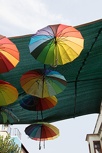 挂着五颜六色的雨伞城市街道装饰 绿色的 装饰的 太阳背景图片