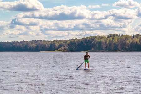桨手年轻男子SUP在湖上冲浪的画面 笑声背景