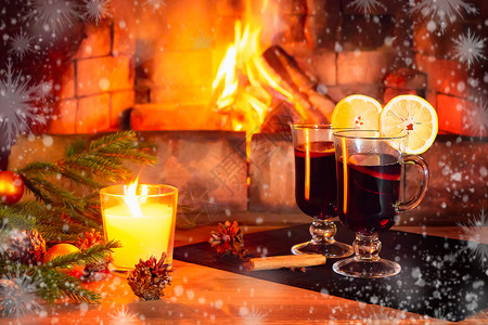 雪火两个杯子 配有面包红酒 一根蜡烛 木板上挂着装饰品的圆形树枝 其背景是一座烧焦的壁炉 由Harfrost和雪花布置 肉桂 视锥细背景
